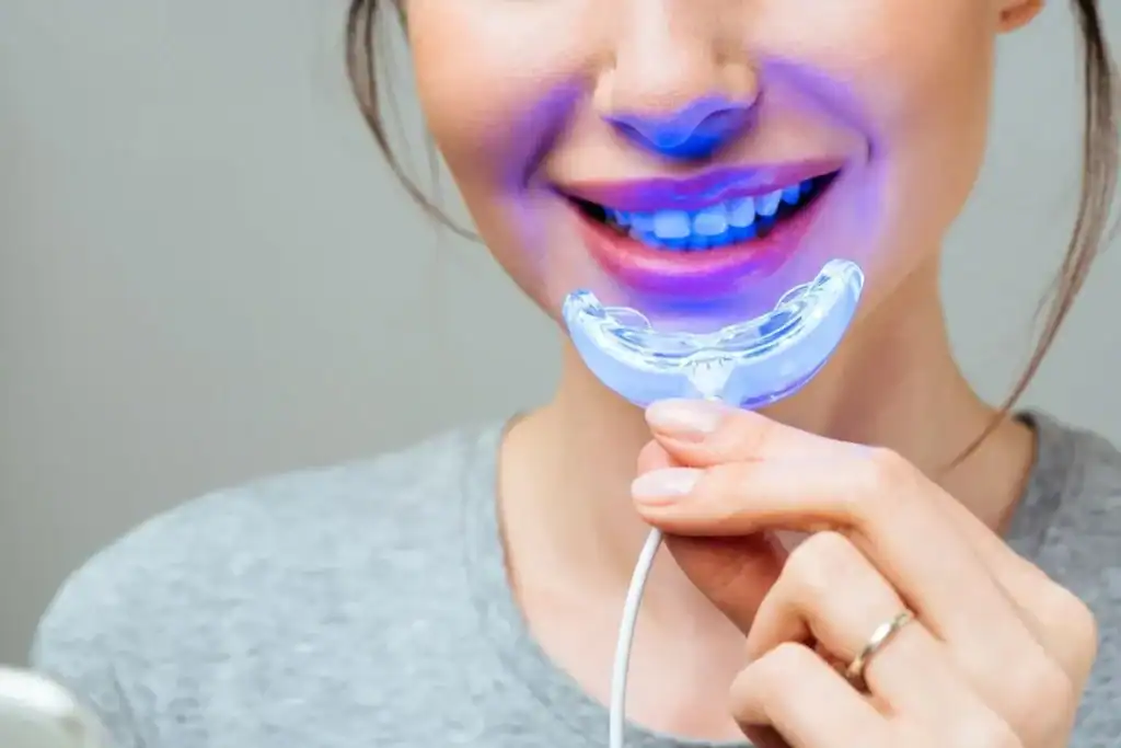 Woman using at-home BBlue Light Teeth Whitening Leamington Spa device for a brighter smile Cannock